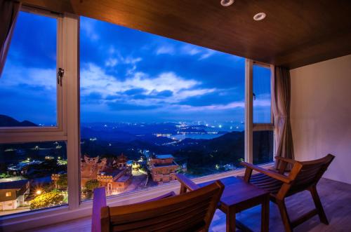 a room with a view of a city at night at Sunshine B&B in Jiufen