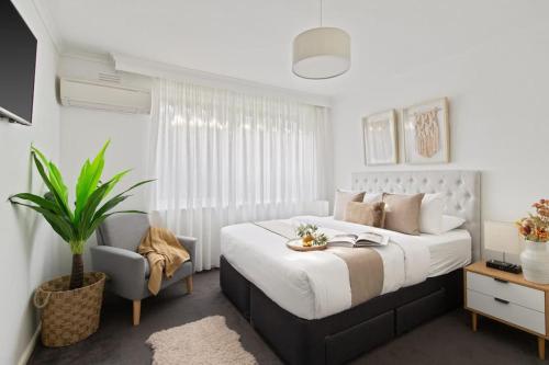 メルボルンにあるThe Elsternwick Abodeの大きなベッドと椅子のある寝室