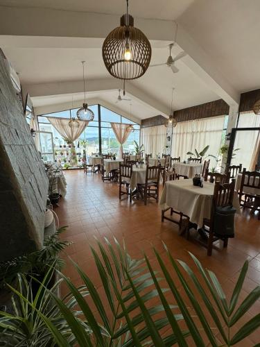 un comedor con mesas, sillas y ventanas en 4 Ases Hotel en Embalse