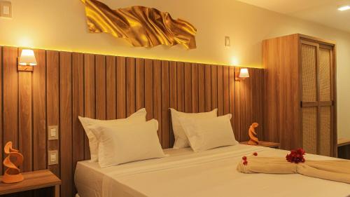a bedroom with a large bed with white pillows at Principe do Mutá Hotel Design in Santa Cruz Cabrália