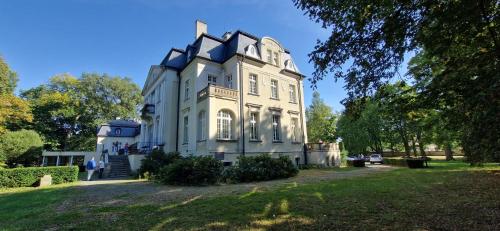 a large white house on top of a field at Pałac Borowa in Borowa