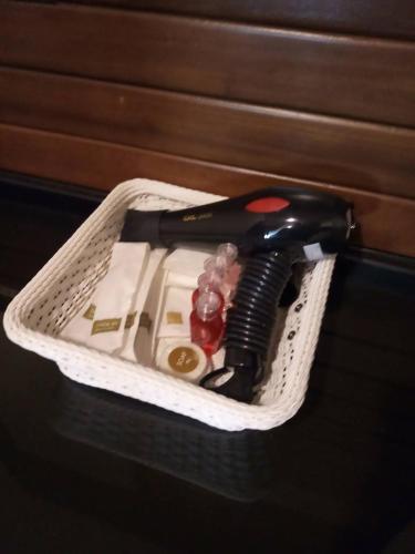 a white basket with a hair dryer in it at The Guest Hotel & Hostel in Chiang Mai