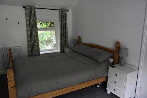 a bedroom with two beds and a window at Terfyn Cottage in Dinorwic