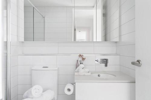 a bathroom with a toilet and a sink and a mirror at Caulfield Elegance: Chic Abode in Melbourne