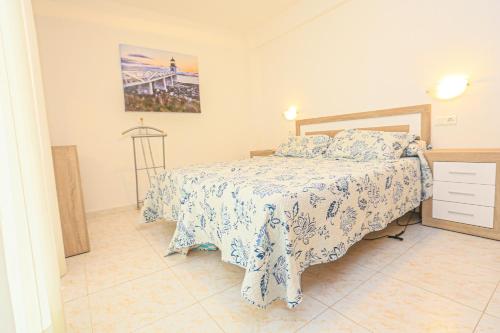 a bedroom with a bed with a blue and white bedspread at Mar Azul Litoral - COSTA DORADA in Cambrils