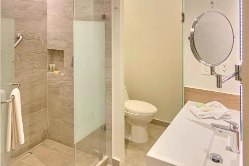 a bathroom with a shower and a toilet and a sink at City Express Plus by Marriott Mexicali in Mexicali
