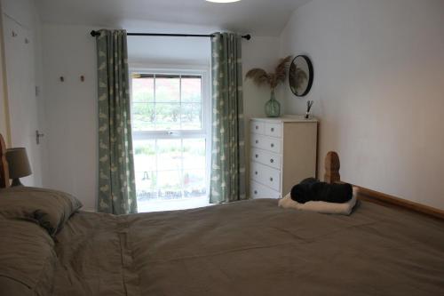 a bedroom with a large bed and a window at Terfyn Cottage in Dinorwic