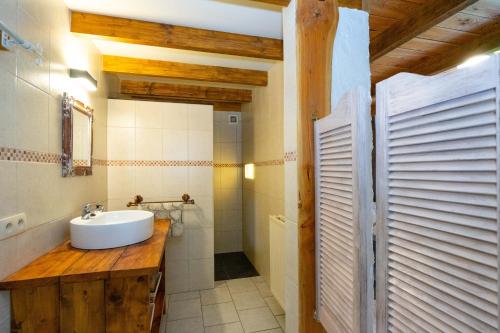 a bathroom with a white sink and a shower at De Patuljak in Houffalize