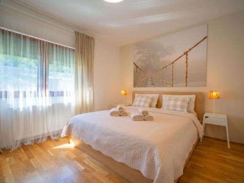 a bedroom with a large bed with a large window at Mala kuća Mia in Bosiljevo