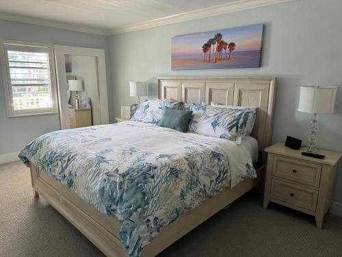 a bedroom with a bed with a blue and white bedspread at Captiva Bayside Villas 1 Bedroom 2 Bath - sleep 4 in Captiva