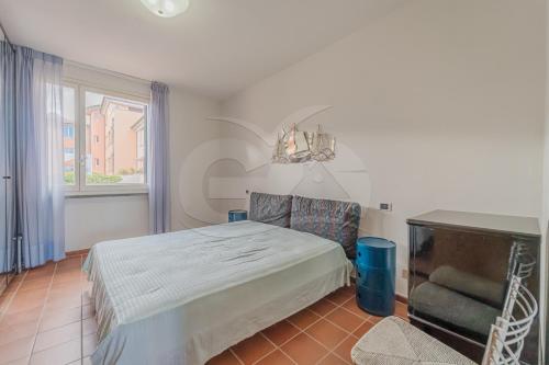 ein Schlafzimmer mit einem Bett, einem Stuhl und einem Fenster in der Unterkunft Casa Bonavista Roof Terrace - Goelba in Marciana Marina