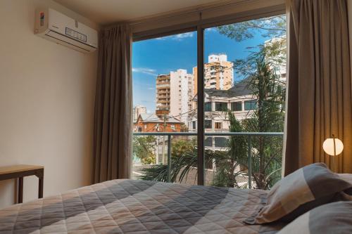 a bedroom with a bed and a large window at Depto en la Costanera Posadas in Posadas