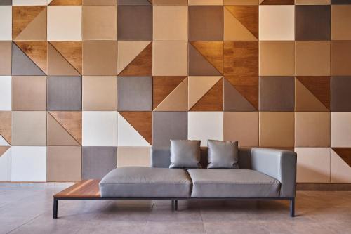 a couch in a living room with a geometric wall at City Express by Marriott Ciudad de México Tlalnepantla in Mexico City