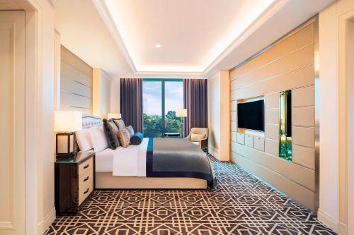 a hotel room with a bed and a television at The St. Regis Kuala Lumpur in Kuala Lumpur