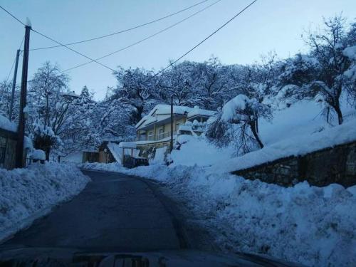 a street covered in snow with a house at Serenity Traditional House in Kalavrita