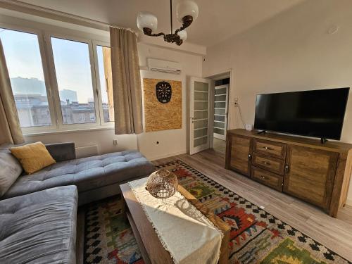 a living room with a couch and a flat screen tv at Loga Apartment in Sarajevo