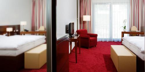 a hotel room with two beds and a red carpet at Hotel Rose in Bretzfeld