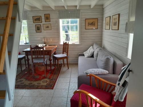a living room with a couch and a table at Lotta´s Cottage in Rimbo