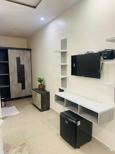 a living room with a tv on a wall at YATRI NIVAS SAGARA ( AC AND NON-AC DELUXE ROOMS) in Sāgar