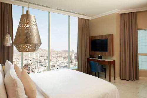 a hotel room with a bed and a large window at Tilal Jabal Al Kabah in Makkah
