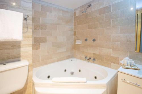 a large bathroom with a tub and a toilet at Metro Mirage Hotel Newport in Newport