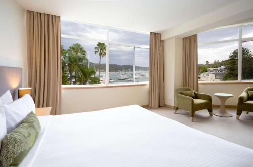 a hotel room with a bed and a large window at Metro Mirage Hotel Newport in Newport