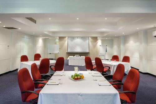 a conference room with white tables and red chairs at Mirage Hotel Newport in Newport