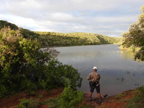 a man standing in front of a lake at African Safari Lodge in Grahamstown