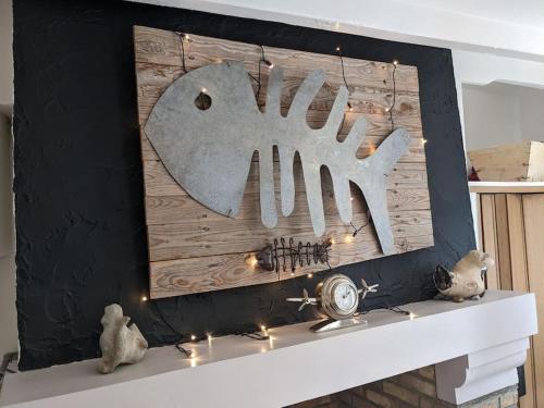 un manteau de cheminée avec des lumières et une horloge. dans l'établissement Maison de pêcheur Souffle de Mer, à Saint-Valery-sur-Somme