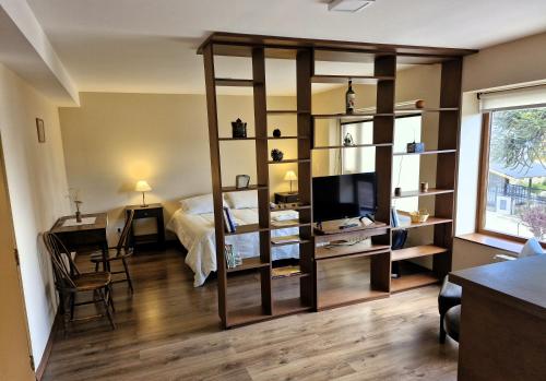 Habitación con cama y estante para libros en Alto Rolando Apartamentos en San Carlos de Bariloche