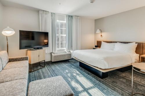 Habitación de hotel con cama y sofá en TownePlace Suites Dallas Arlington North, en Arlington
