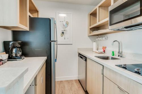 a kitchen with a refrigerator and a sink at TownePlace Suites Dallas Arlington North in Arlington