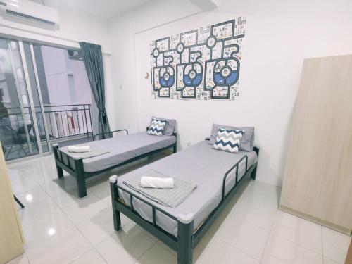 a room with two beds and a picture on the wall at Cozy Home Kampar (UTAR) 5bedrooms 10pax Free WiFi in Kampar