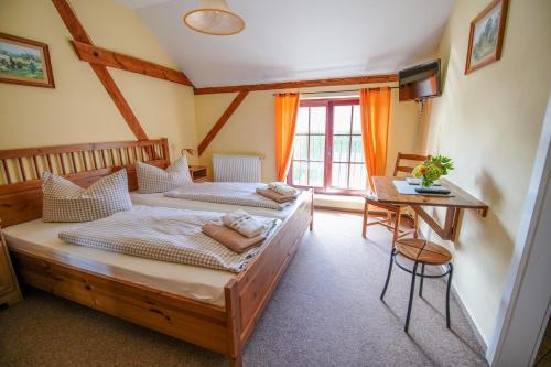 1 dormitorio con 2 camas y mesa en Scheunenherberge en Unterspreewald