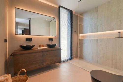 een badkamer met 2 wastafels en een grote spiegel bij Graham Holiday Rentals - Symphony in Benissa