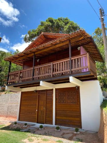 a house with a balcony on top of it at Chalés Requinte em Pedra Azul in Pedra Azul