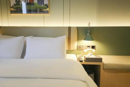 a bedroom with a bed and a lamp and a phone at Hotel Aria in Cheonan
