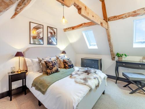 1 dormitorio con cama y escritorio en The Old Smithy, en West Ashton