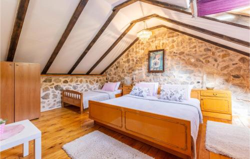 2 Betten in einem Zimmer mit einer Steinmauer in der Unterkunft Pet Friendly Home In Vrgorac With Wi-fi in Vrgorac