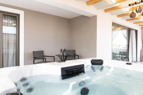 a jacuzzi tub in a living room with a table at Diana Palace Hotel Zakynthos in Argasi