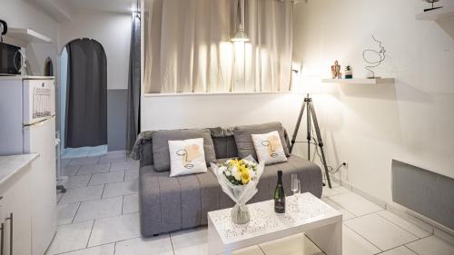 un salon avec un canapé et une table avec des fleurs dans l'établissement Smart Confort 9 - Appartement confort et stylé, à Troyes