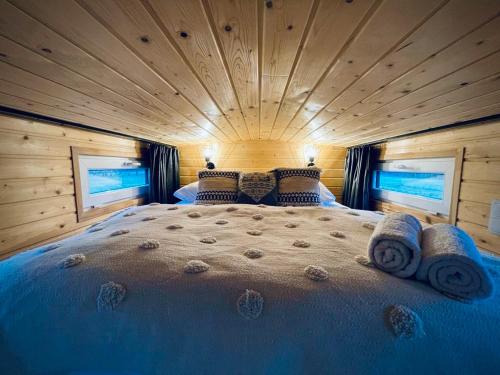 a bedroom with a large bed in a log cabin at Tiny House Village (850m od Suntago) in Grabce-Towarzystwo