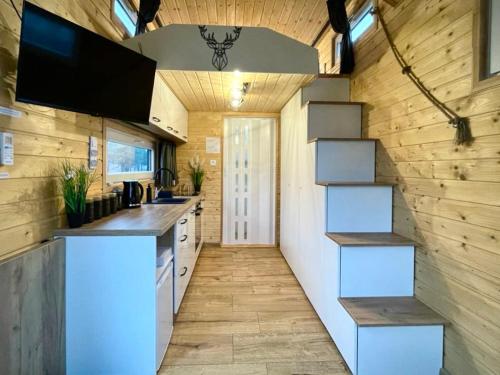 una cocina con una escalera en una casa pequeña en Tiny House Village (850m od Suntago) en Grabce