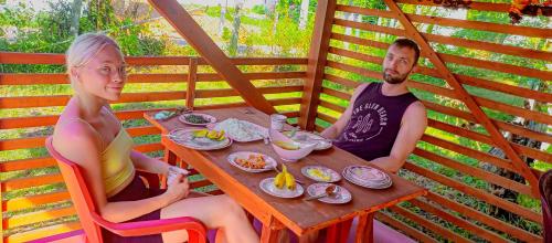 a man and a woman sitting at a table with food at Happy Morning Bliss. in Mirissa