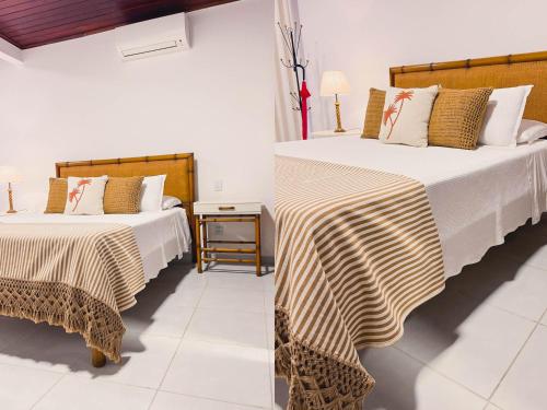 2 camas en una habitación con paredes blancas en Amarilis Pousada Arraial d'Ajuda, en Arraial d'Ajuda