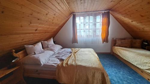 Schlafzimmer im Dachgeschoss mit einem Bett und einem Fenster in der Unterkunft Balla Apartmanház in Siófok