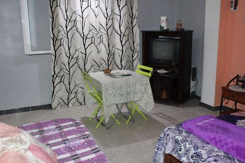 a living room with a table and a tv at Niveau de Villa entre Béjaïa et Jijel (Ziama) in Jijel