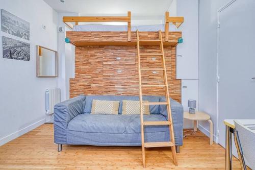 - un salon avec un canapé bleu et des lits superposés dans l'établissement Charmant Studio Boulevard Voltaire - II, à Paris