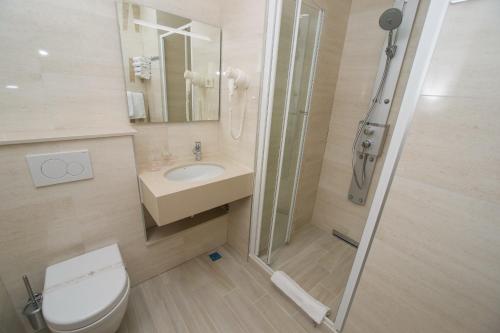 a bathroom with a toilet and a sink and a shower at Hotel Biokovo in Makarska