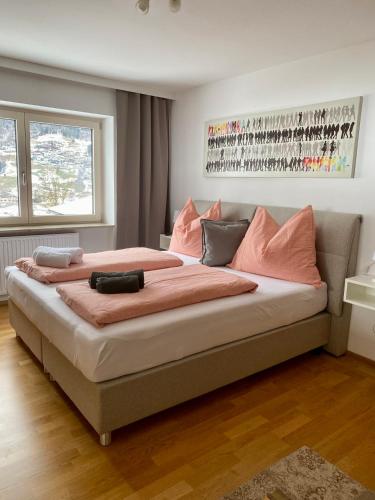 a large bed with pink pillows in a bedroom at Ferienwohnung Soller in Bramberg am Wildkogel
